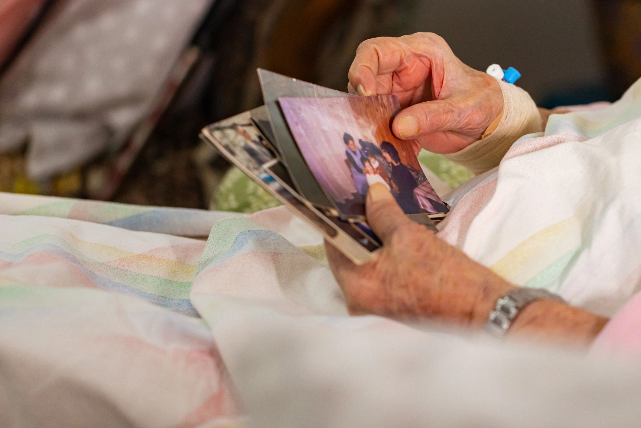 Elderly woman reflecting on family memories with photographs